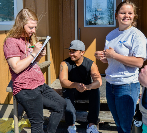 Prince William Sound College students hanging out on the steps of student housing in Valdez, Alaska.